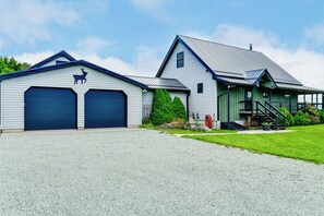 A two-story building with a garage, a staircase, and a covered porch. - Mtn-view Luxe Catskills Retreat for Groups (Hobart)