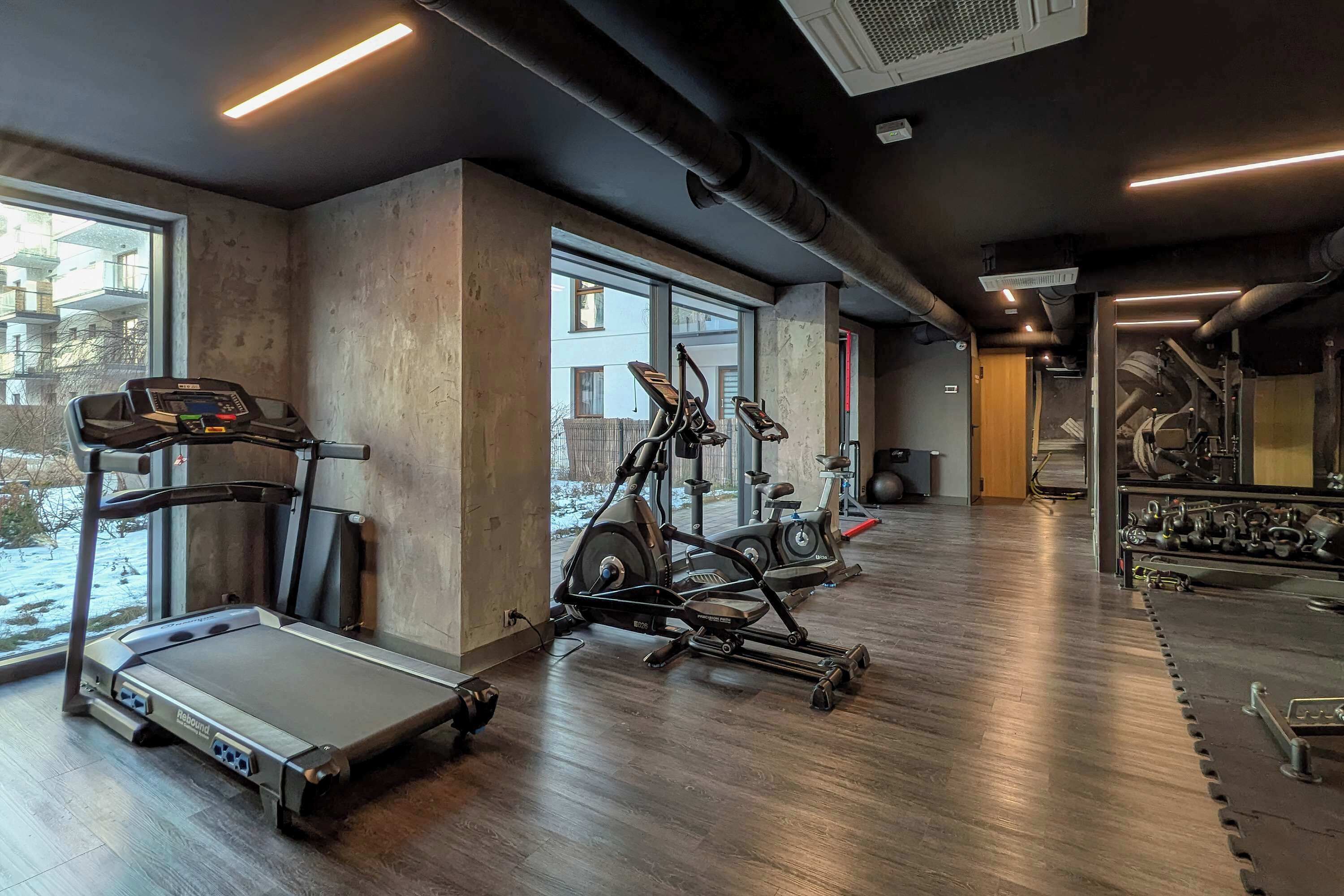 A gym with treadmills, elliptical machines, and weight equipment.