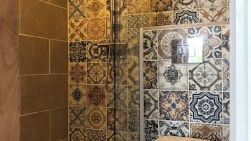 Een douche, milieuvriendelijk toiletgerief, handdoeken, toiletpapier