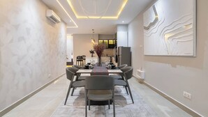 A modern dining area with a rectangular table, grey chairs, and a decorative centerpiece. - Chic Waterfront 2BR in Lekki Phase 1 - 5 Star Apt (Lekki)