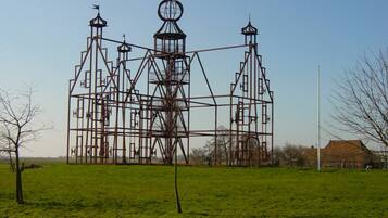 A large metal structure resembling a church or cathedral in a grassy field.