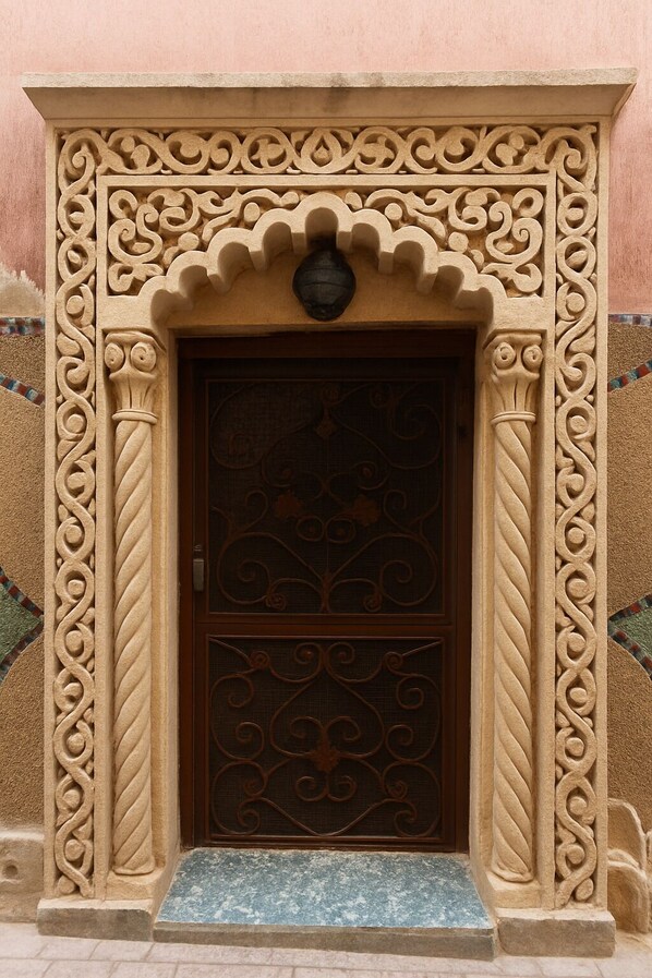 A door with intricate carvings and a small step leading up to it.