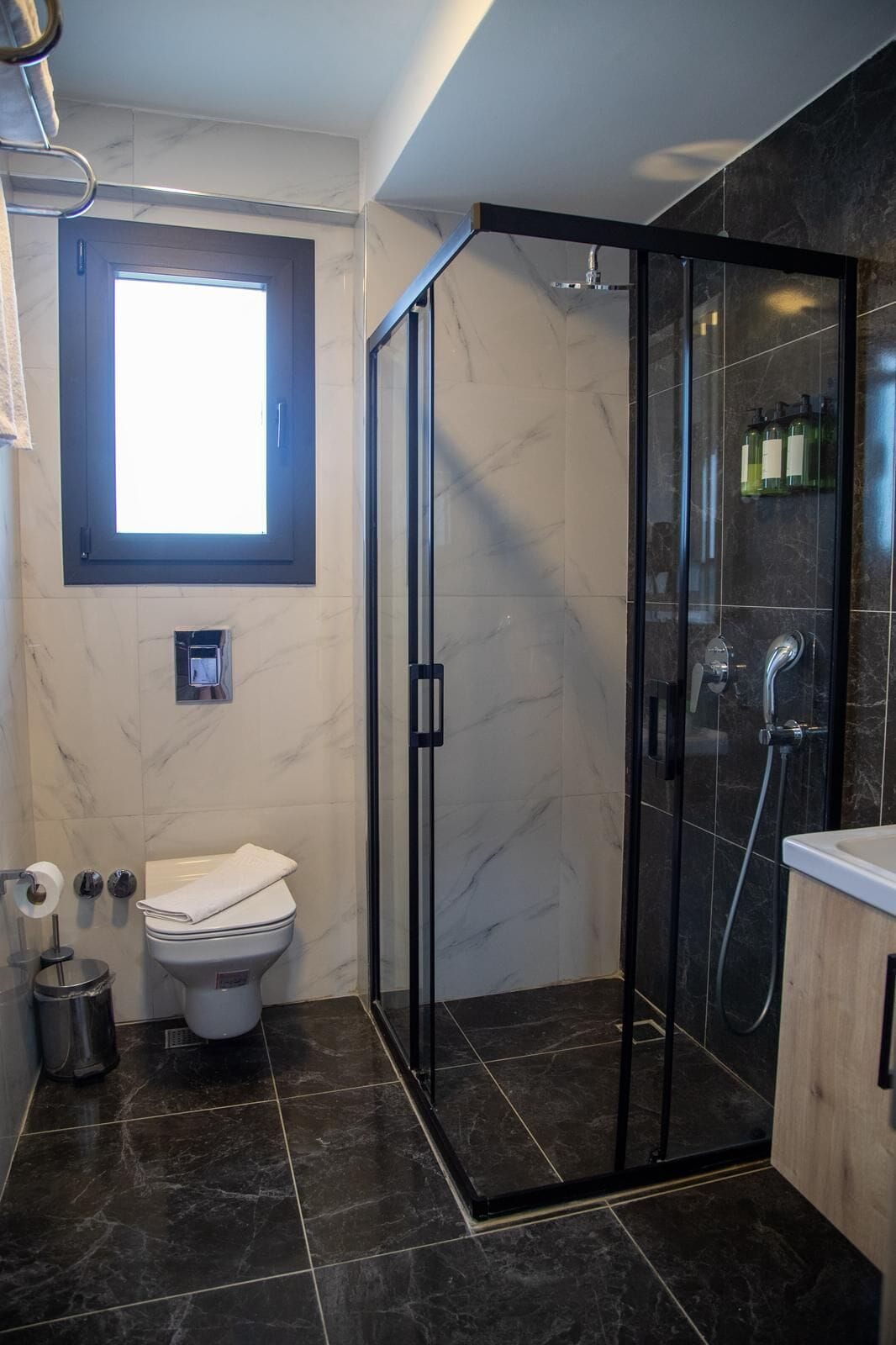 Un baño moderno con ducha envuelta en vidrio, inodoro y lavabo.