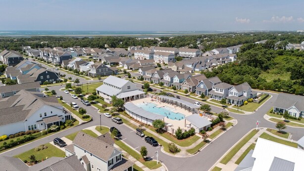 A residential area with houses, a swimming pool, and a road. - Sandmann's By The Sea - w/ Golf Cart! (Beaufort)