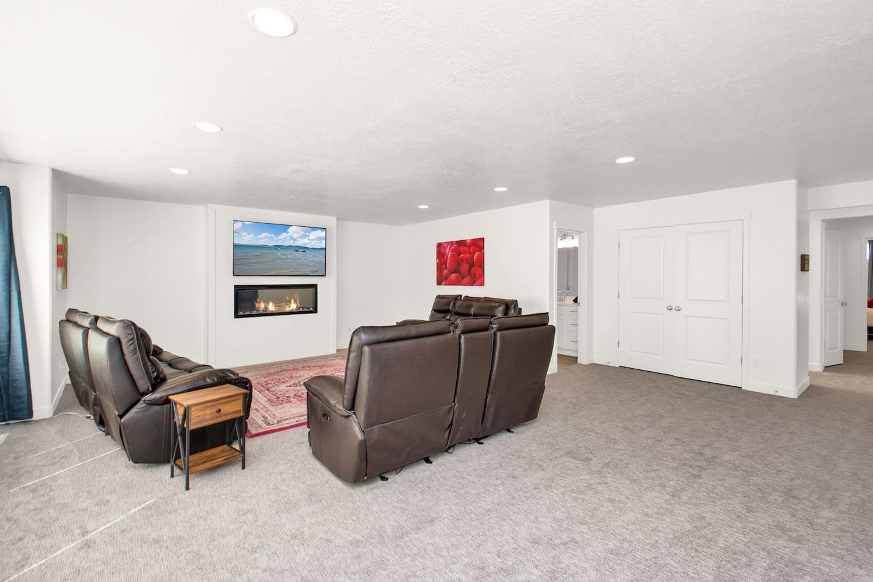 A living room with a fireplace, a large sofa, and a television.