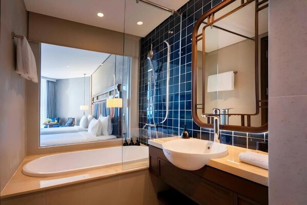 Ein modernes Badezimmer mit einem großen Spiegel, einer Badewanne und einem Waschbecken.