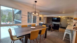 A modern kitchen with a dining area, large windows, and a TV. - Keystone Charm: Wild Irishman 3br Mountain Escape 3 Bedroom Condo (Keystone)
