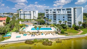 A hotel with a pool, multiple floors, and a view of the water. - Dolphin Point 702a 2 Bedroom Condo (Destin)