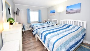 A bedroom with two beds, a dresser, a mirror, a window with curtains, and a beach-themed painting on the wall. - Diamond Head 502 1 Bedroom Condo (Ocean City)
