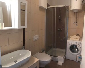 Een douche, handdoeken, zeep, toiletpapier