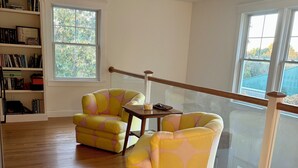 A spacious room with wooden flooring, a large window, and a bookshelf. - August or weekly rental bike to beach, walk to tennis! (Westerly)