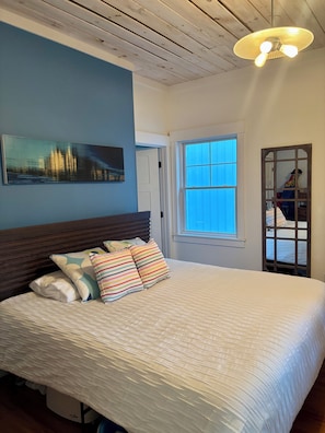 A bedroom with a bed, a window, a ceiling fan, and a painting on the wall. - August or weekly rental bike to beach, walk to tennis! (Westerly)