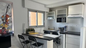 A compact kitchen with a dining area, a washing machine, and a microwave. - The Capitole C403 Apartment with exceptional sea view – Fréjus Beach (Fréjus)