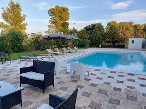 Piscine extérieure en saison, parasols, chaises longues