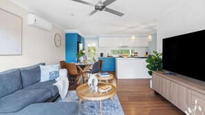 A modern living room with a sofa, coffee table, and TV. - Kangaroo Sanctuary (Sanctuary Point)