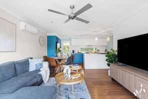 A modern living room with a sofa, coffee table, and TV. - Kangaroo Sanctuary (Sanctuary Point)