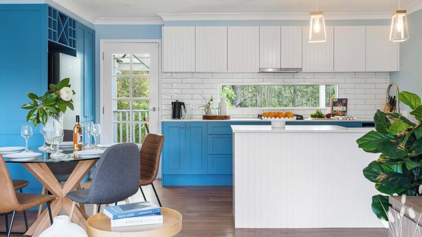 A modern kitchen with blue cabinets, a white island, and pendant lighting. - Kangaroo Sanctuary (Sanctuary Point)