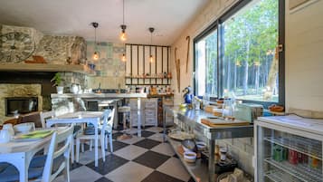 Una cocina con suelo a cuadros, pared de piedra y un amplio ventanal con vistas a un bosque.