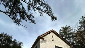 A two-story building with a stone facade, a tiled roof, and a small porch area. - Bed & Breakfast “La Lisière” with Mountain View, Wi-Fi and Air Conditioning (Brantes)