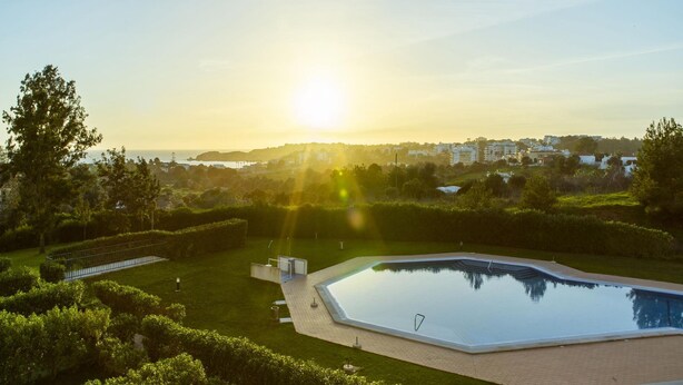 A swimming pool with a clear view of the surrounding landscape and distant buildings. - B85 - Seasun Step Apartment in Praia da Rocha (Portimão)