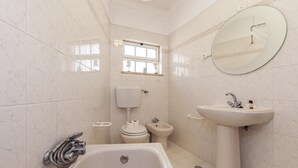 A bathroom with a bathtub, toilet, bidet, sink, and a window. - A75 - Casa da Ponte 1 Bed Flat in Lagos (Lagos)