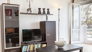 A modern living room with a flat-screen TV, a bookshelf, and a dining table. - B77 - Im on Avenida Apartment in Lagos (Lagos)