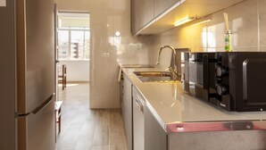 Una cucina moderna con isola in acciaio inossidabile, forno a incasso e microonde.