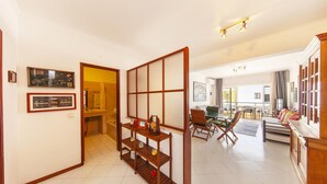 A spacious living area with a traditional Japanese sliding door, a wooden coffee table, and a dining area with chairs and a table. - A02 - Casa Topazio in Quarteira (Loulé)