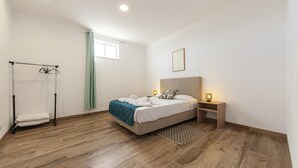 Une chambre à coucher comprenant un lit, une table de chevet, une lampe et un porte-serviettes.