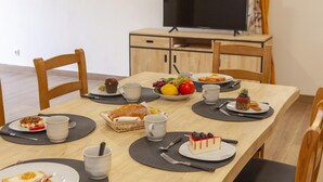 Una mesa de comedor dispuesta con platos de comida, tazas y cubiertos.