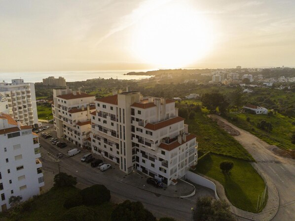 A multi-story residential building with a parking area in front. - B01 - Mar a Vista Rocha Apartment (Portimão)