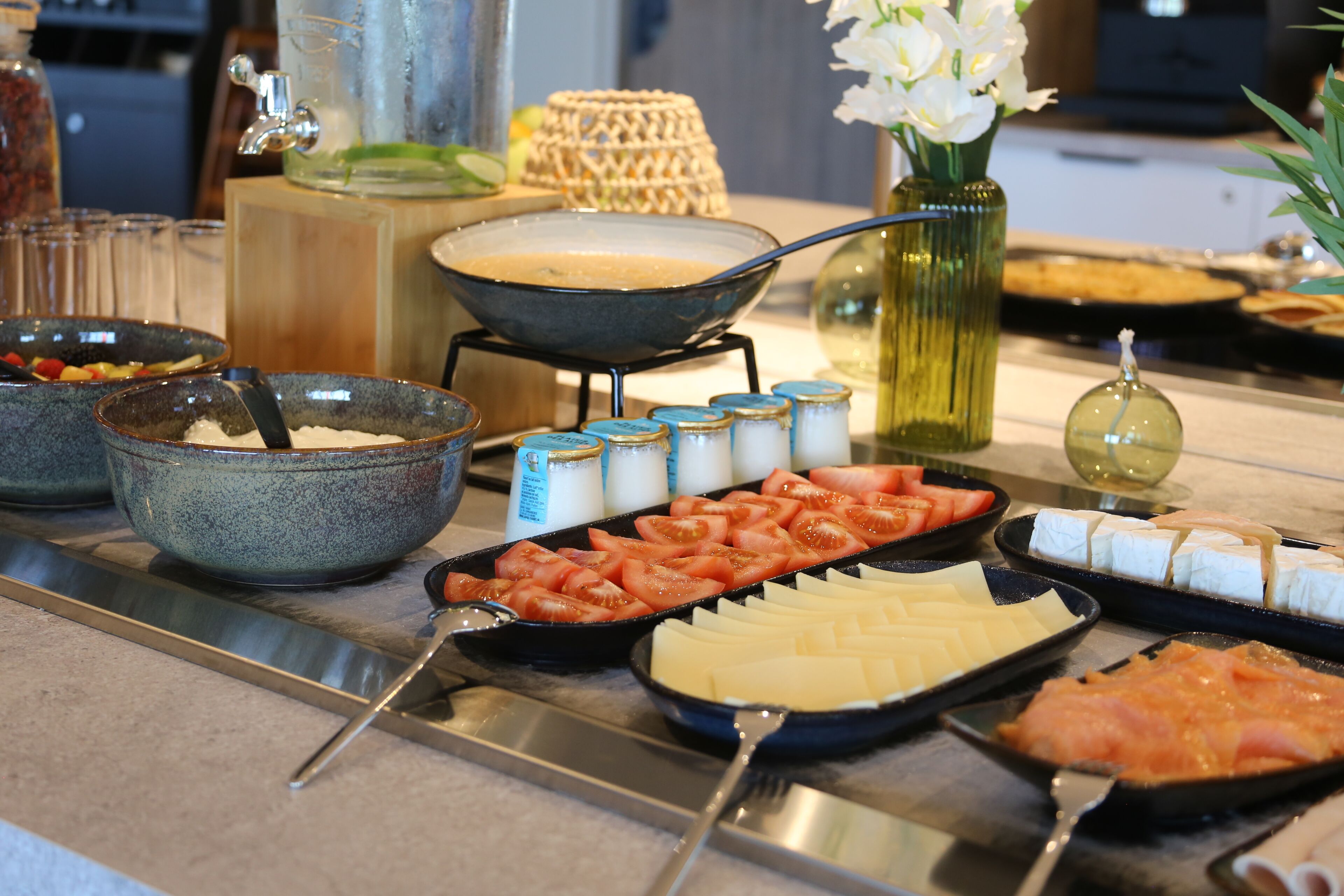 A buffet setup with various food items and condiments.