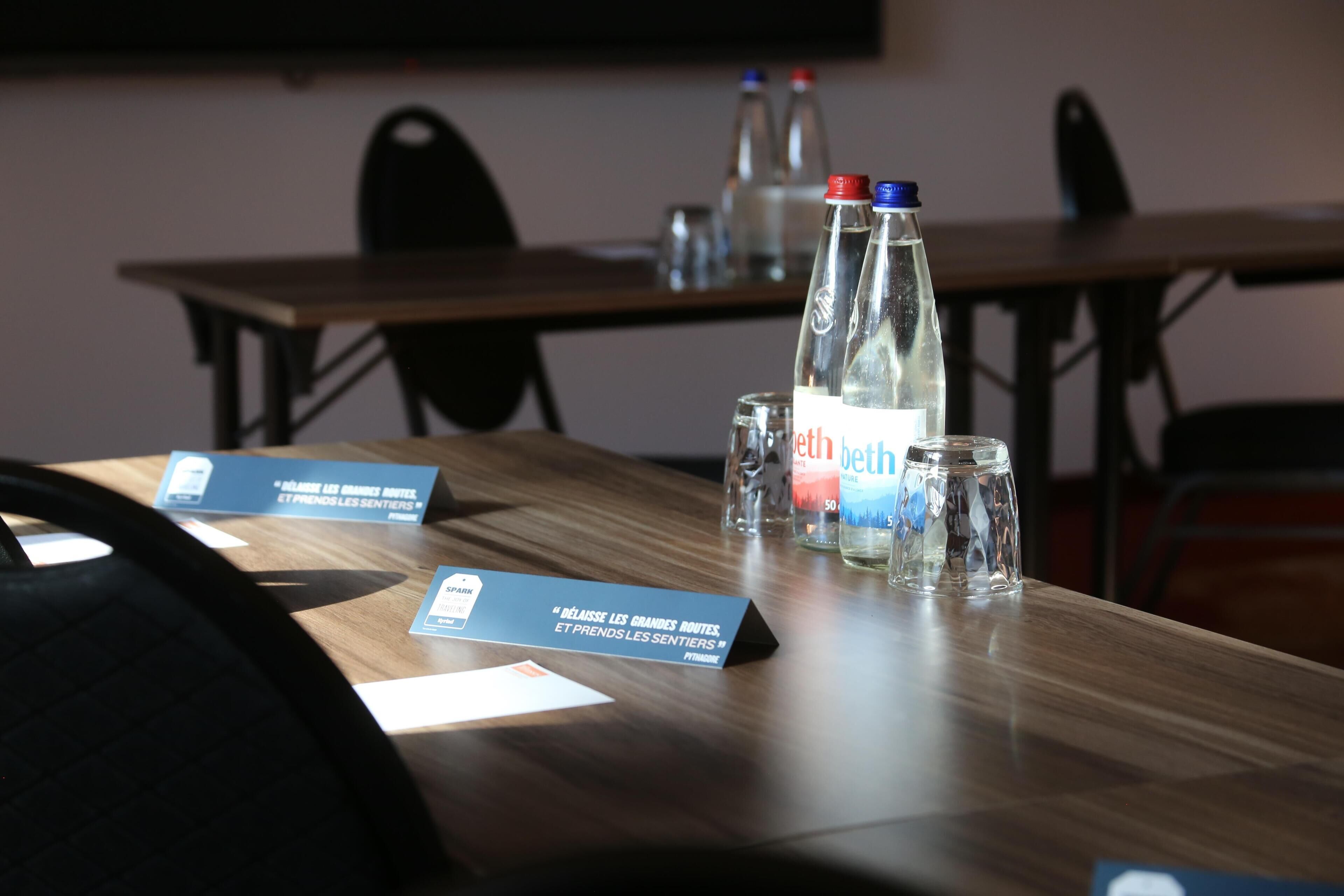 A conference table with name cards, water bottles, and glasses.