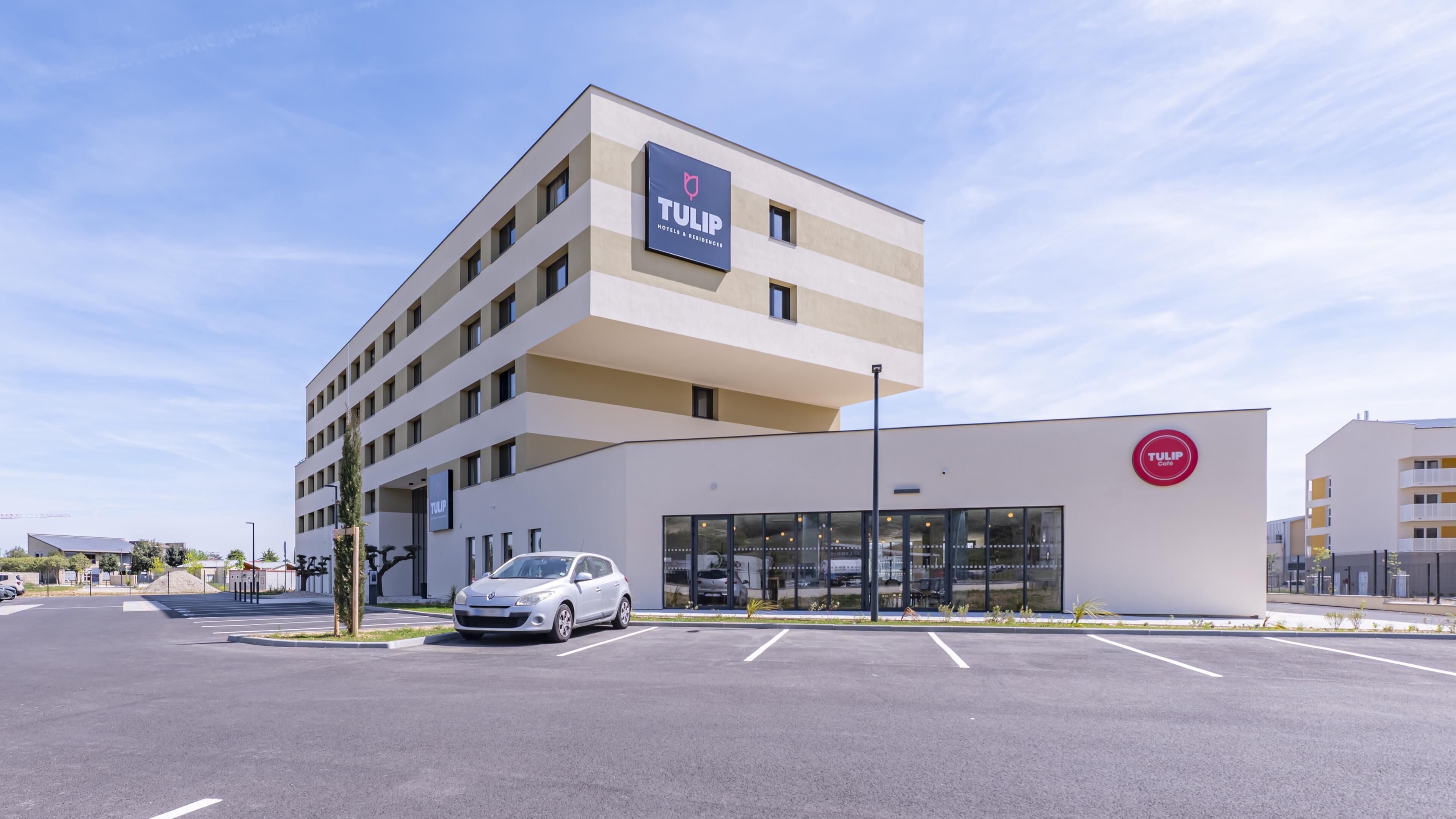 Un hôtel moderne, reconnaissable à son enseigne où l’on peut lire : « TULIP HOTELS & RESIDENCES ».