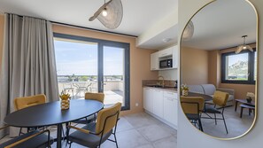 A modern apartment with a dining area, kitchen, and balcony with a view. - Tulip Hotels & Residences - Valence Sud Guilherand Granges (Guilherand-Granges)