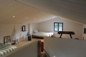 A bedroom with a bed, a window, a sailboat model, and a foosball table. - Superb property 200 metres from the beach at Luzeronde - Ile de Noirmoutier (Noirmoutier-en-l'Île)