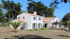A two-story white house with a tiled roof, surrounded by trees and a grassy yard. - Superb property 200 metres from the beach at Luzeronde - Ile de Noirmoutier (Noirmoutier-en-l'Île)
