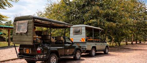 A safari vehicle with a covered cargo area and a spare wheel mounted on the back.
