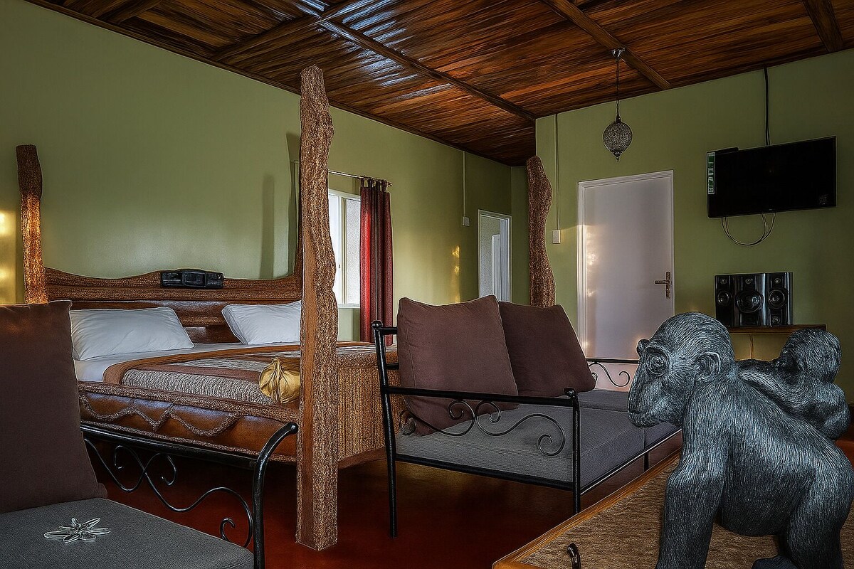 Una habitación con cama, una silla, un televisor y una escultura.