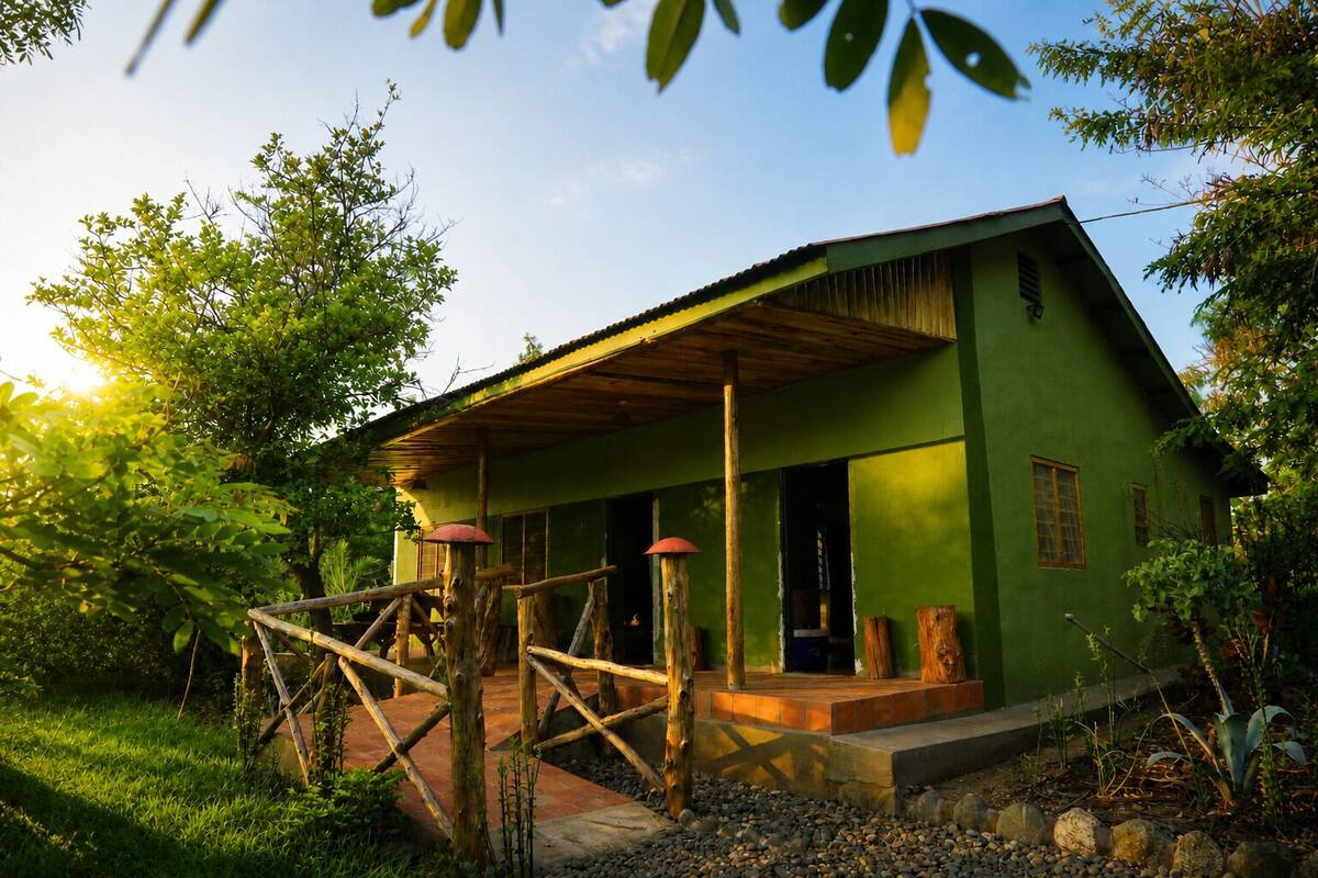 Un bâtiment écologique doté d’un porche en bois, entouré de verdure.