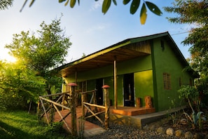 Un bâtiment écologique doté d’un porche en bois, entouré de verdure.