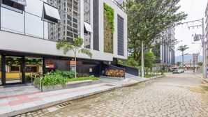Un edificio moderno con un elemento d'acqua sul davanti, un vialetto lastricato e aree verdi.