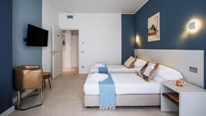 Une chambre d’hôtel avec deux lits, une télévision, une petite table et une chaise.