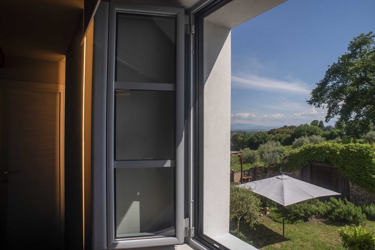 A window with a view of a garden and a wooden structure.