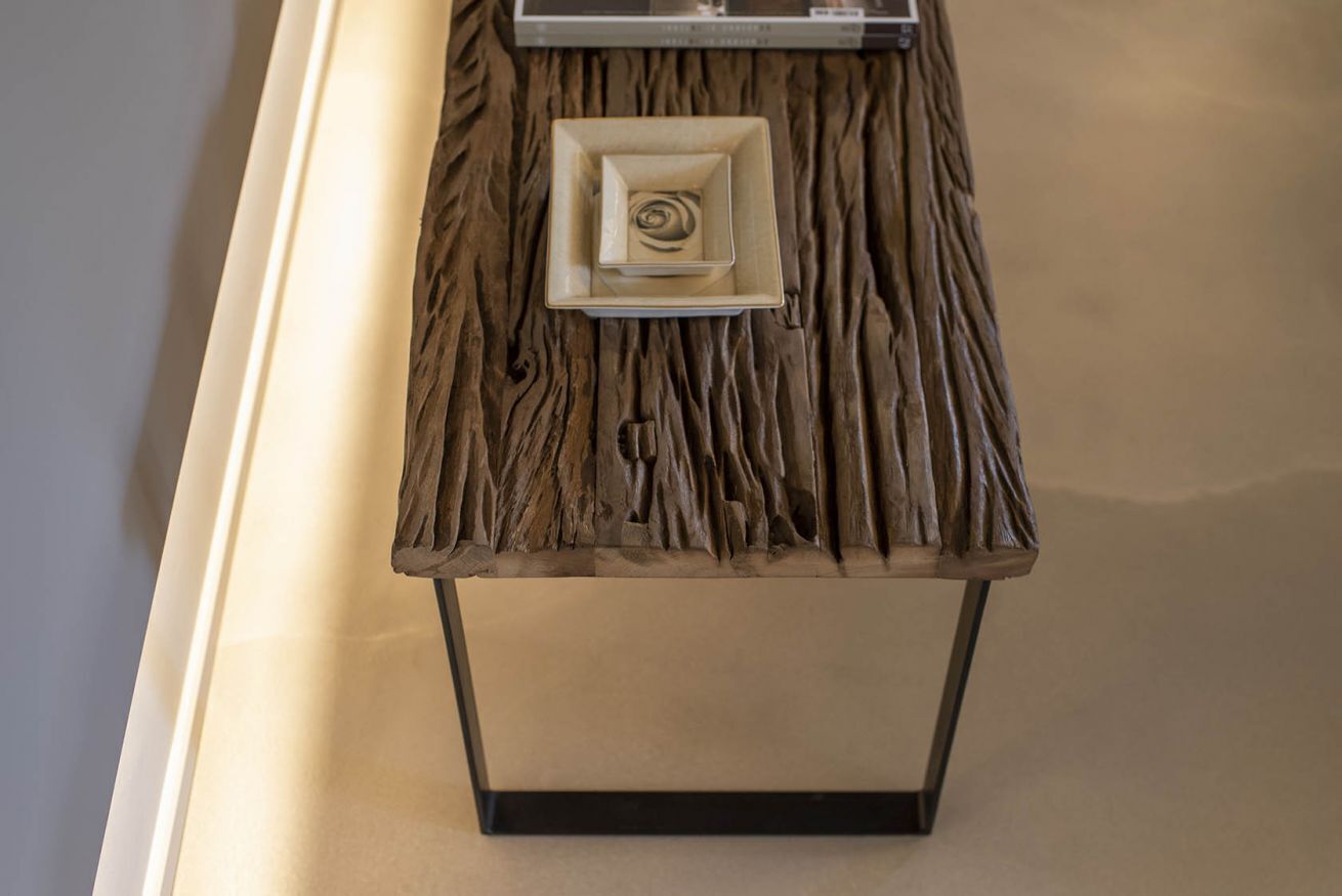 Une table en bois, avec un pied carré et un plateau rectangulaire.