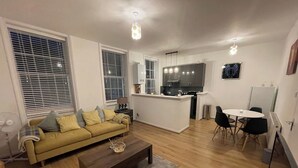 A modern living room with a sofa, coffee table, and dining area. - Cozy 1-bedroom Apartment Near Margate Seafront (Margate)
