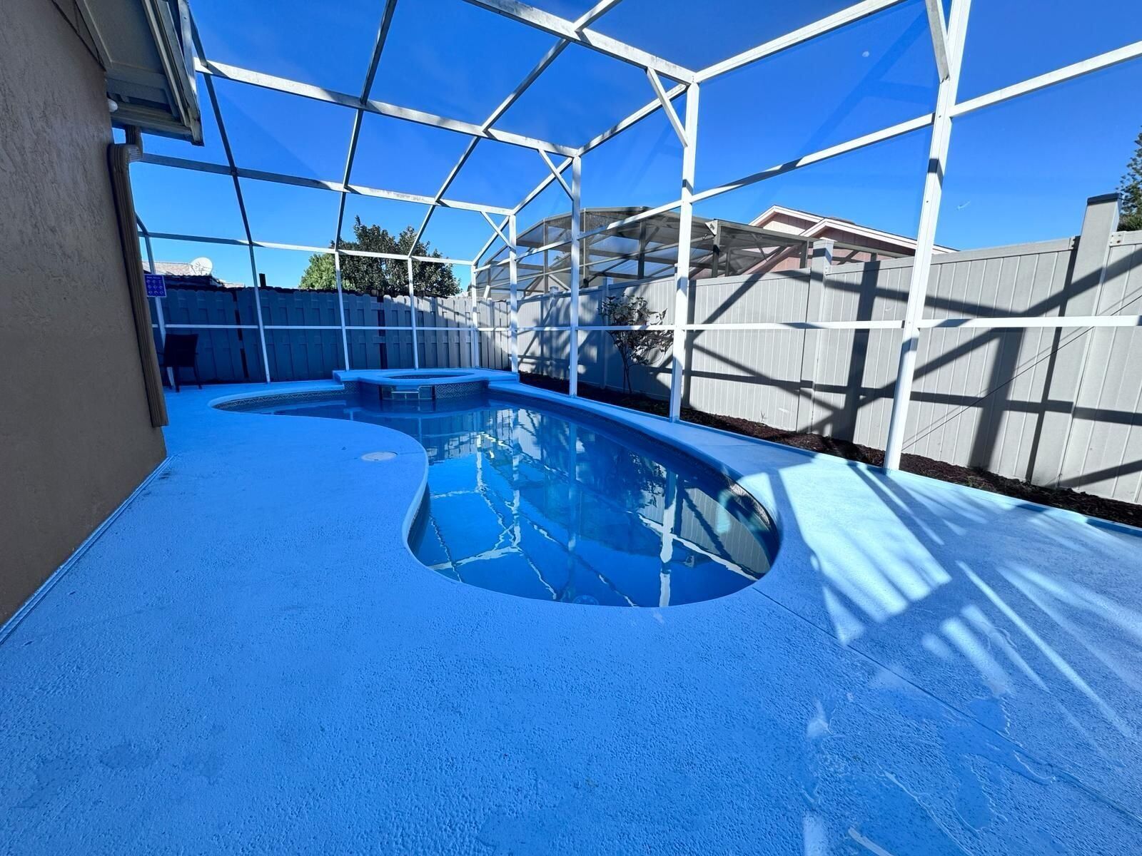 Une piscine intérieure dotée d’un sol bleu et d’une eau claire, entourée d’une structure en métal.