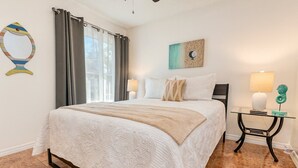Una camera da letto con un letto grande, un comodino con una lampada e un quadro appeso al muro.