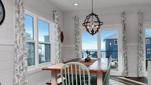 A dining area with a wooden table, chairs, and a hanging light fixture. - ☀️ Pet Friendly - Steps to Beach - Private Pool and Hot Tub - The Lazy Turtle ☀️ (Cape San Blas)