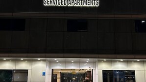 Ein Gebäude mit einem Schild, auf dem 'Medmak Al-Ghad Serviced Apartments' in Arabisch und Englisch steht.